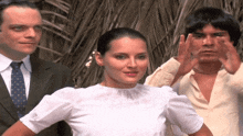 a man in a suit and tie is standing next to a woman in a white top