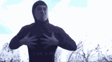 a man is standing in a field with his hands on his chest and the words `` i am a fucking god '' below him .