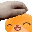 a person is petting a teddy bear 's head with their hand .