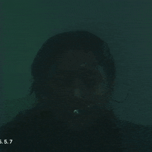 a close up of a woman 's face with a bubble in her mouth and the date 5.5.7