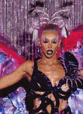 a woman in a very colorful costume is standing in front of a purple background