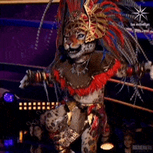 a person in a leopard costume with feathers on their head