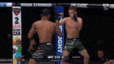 two men in a boxing ring with a sign that says vegas stronger on it