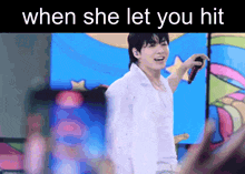a man singing into a microphone with the words when she let you hit above him