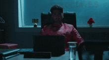 a man sits at a desk in front of a window with the word associates written on it
