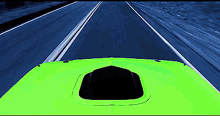 a green car is driving down a highway with a hood scoop