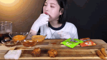 a woman sitting at a table eating food with a bag of goody 's in front of her