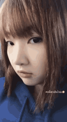 a close up of a woman 's face with a blue hoodie