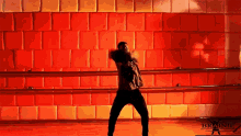 a man is dancing in front of a red wall that says brainii
