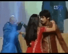 a woman in a red dress is hugging a man in a brown shirt ..