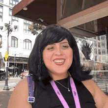 a woman wearing a lanyard that says vogue smiles for the camera
