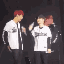 a couple of men are standing next to each other on a stage and laughing .