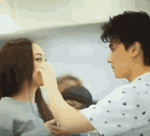 a man is touching a woman 's face with his hand .