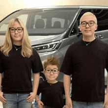 a group of people standing in front of a car
