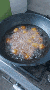 a frying pan filled with oil and fried food on a stove