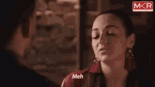 a woman in a red shirt is looking at a man .