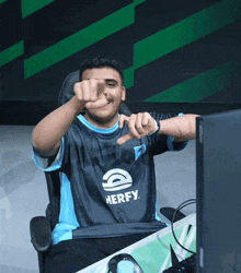 a man sitting in front of a computer wearing a shirt that says herfy