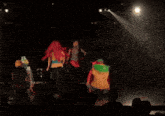 a group of people are on a stage in front of a spotlight