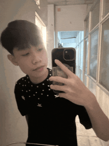 a young man taking a picture of himself in the mirror