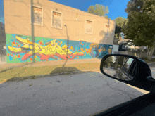 a car is driving past a building with graffiti on the side