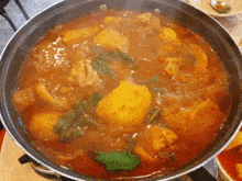 a pot of stew with meat and potatoes is being cooked on a stove