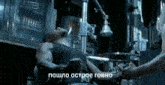 a man in a black tank top is laying in an ambulance with russian writing on the bottom of the image