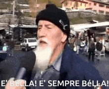 a man with a beard is talking into a microphone with the words e bella e sempre bella
