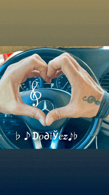 a person making a heart shape with their hands in front of a mercedes