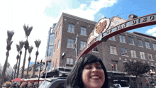 a woman smiles in front of a sign that says city of san diego on it