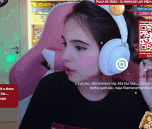 a woman wearing headphones is watching a video with a qr code on the screen