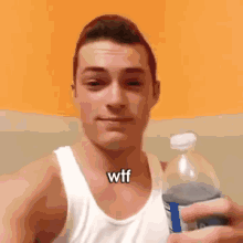 a man in a white tank top is holding a bottle of soda and the word wtf is on his chest