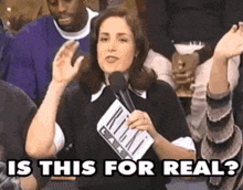 a woman is holding a microphone and says is this for real .
