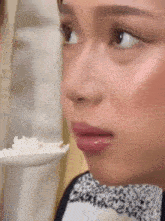 a woman is eating rice from a spoon .