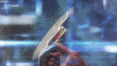 a person is holding a futuristic device in their hand in front of a screen .