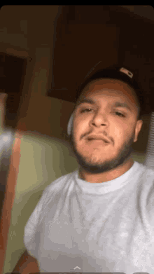 a man with a beard is wearing a white t-shirt