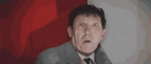a man in a suit and tie is making a funny face .