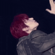 a man with red hair is wearing a denim jacket
