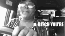 a woman wearing sunglasses is driving a car and says bitch you 're .