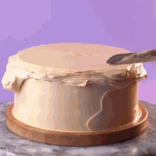 a cake on a wooden cutting board with frosting on it