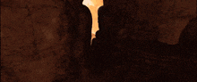 a silhouette of a person standing in a cave