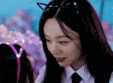 a woman wearing a cat ear headband looks down at something