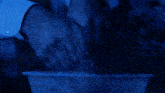 a person 's arm is visible in a dark blue light