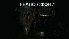 a man in a trench coat and hat stands in a dark room with the words " ebao ofhni " written above him
