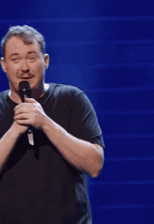 a man is holding a microphone with the words not bad written below him