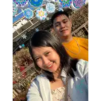 a man and a woman are posing for a picture in front of snowflakes