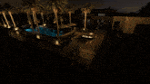 a large swimming pool is lit up at night with palm trees in the background