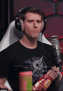 a man wearing headphones is holding a bag of lays chips