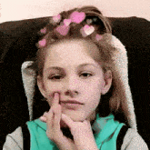a young girl with pink hearts in her hair is making a funny face