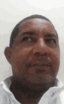a man with a beard is wearing a white shirt and looking up .