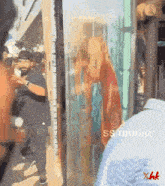 a man in a striped shirt is standing in front of a window that says ss music